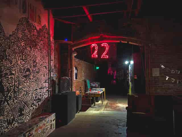 Industrial event space with exposed brick and neon signage for creative gatherings.