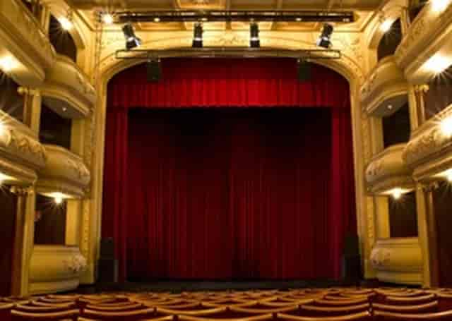 Elegant theater stage with red curtain in 268-seat venue for events and performances.