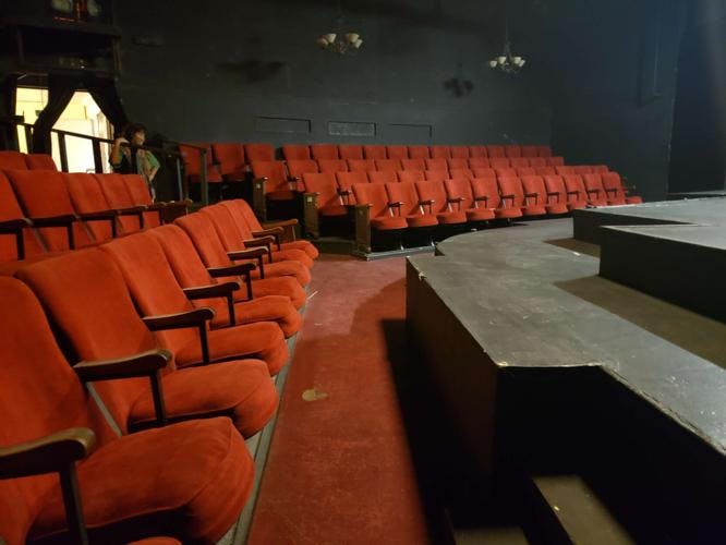 268-seat theater with plush red chairs, ideal for performances and corporate events.