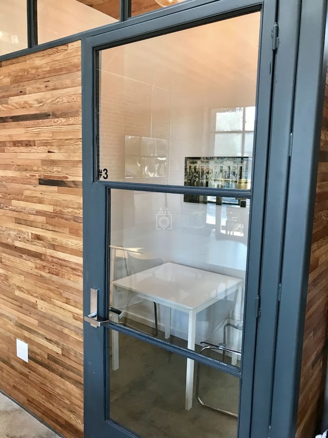 Modern Iona meeting room with glass door, ideal for collaborative brainstorming sessions.