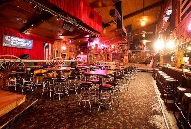 Dance floor in rustic Cowboy Country venue with red curtains for events and performances.