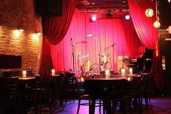 Cozy Hotel Cafe Main Stage with red curtains, perfect for live events and gatherings.