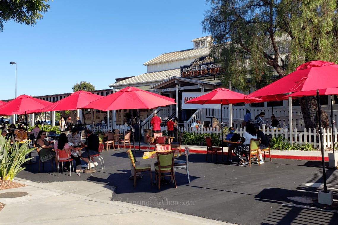 Vibrant outdoor patio with colorful umbrellas for casual gatherings at Lucille's BBQ.