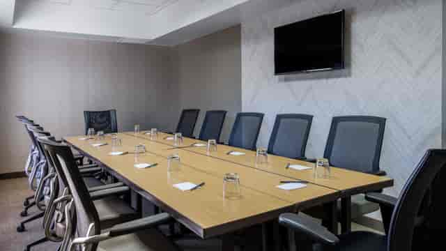 Stylish meeting room with wooden table, ergonomic chairs for professional events.