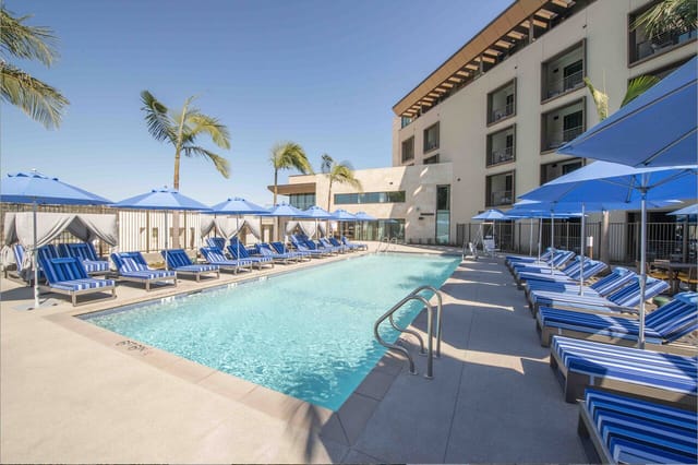 Lounge area at Legacy Resort Hotel with pool, umbrellas, ideal for networking events.