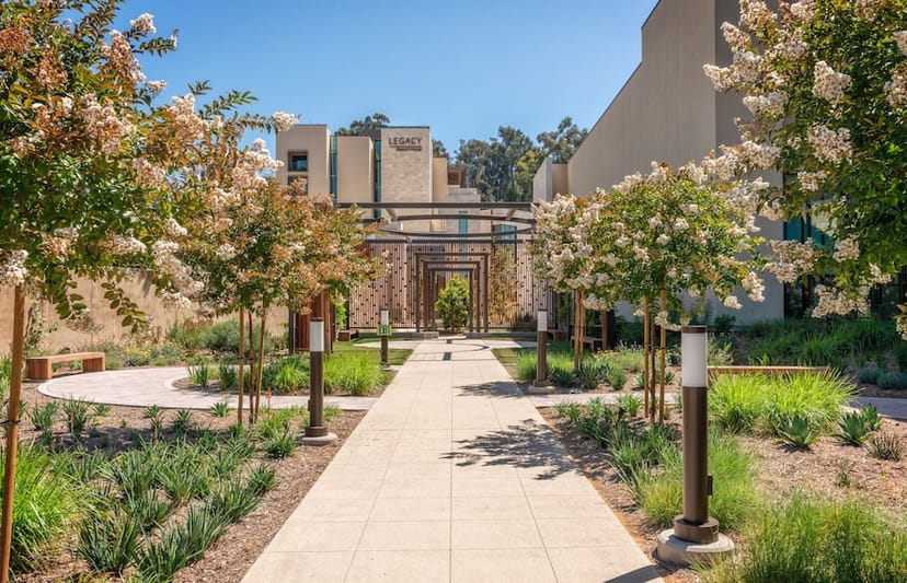 Legacy Grand Plaza pathway, lush greenery, ideal for outdoor events and gatherings.