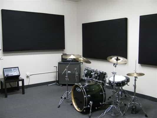 Soundproof rehearsal studio with drum set, ideal for creative workshops and team-building events.
