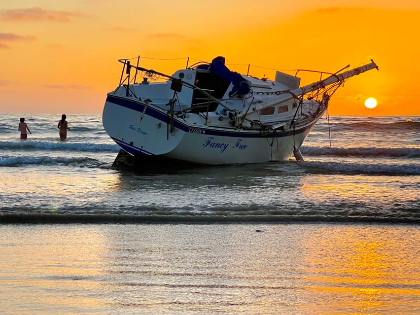Sunset beach view with stranded boat, perfect for outdoor events and team-building activities.