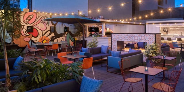 Vibrant outdoor event space at Kimpton Alma Hotel with stylish seating and fire feature.