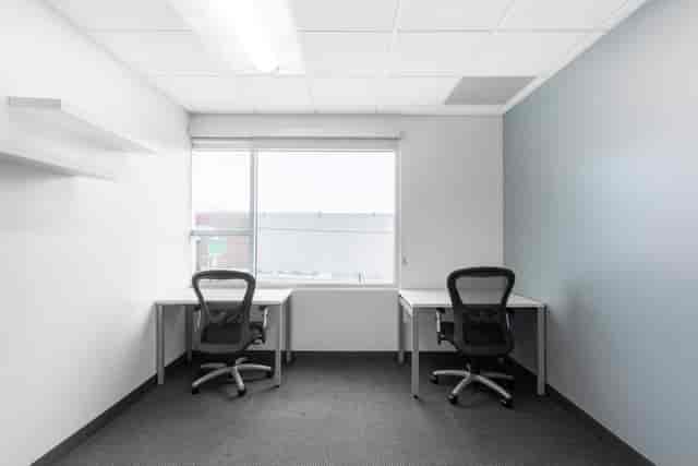 Minimalist office meeting space with ergonomic chairs, ideal for team brainstorming sessions.