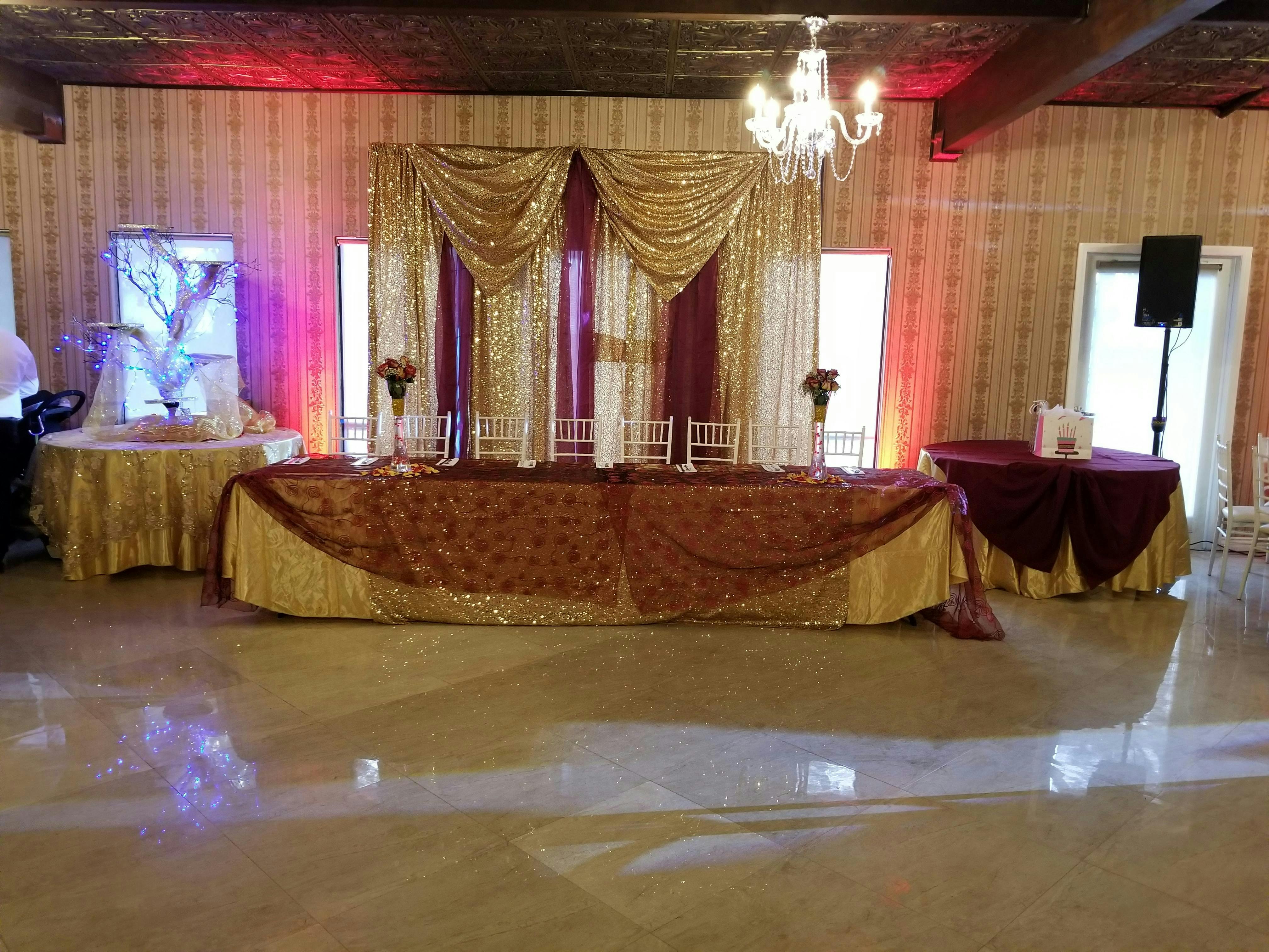 Elegant Grand Ballroom with gold and burgundy decor for weddings and upscale events.