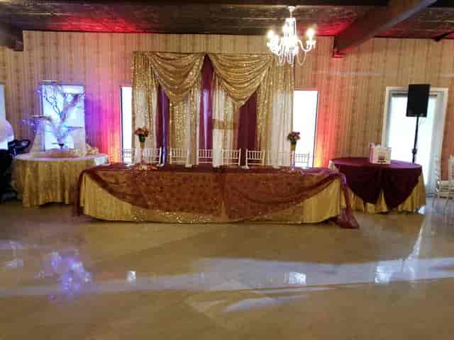 Elegant Grand Ballroom with gold and burgundy decor for weddings and upscale events.