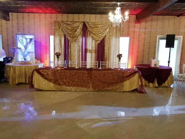 Elegant Grand Ballroom with gold and burgundy decor for weddings and upscale events.