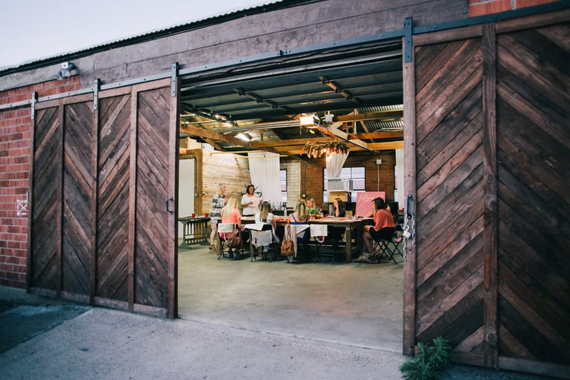 Versatile event space with rustic wooden doors, ideal for workshops and team-building.