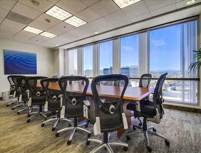 Modern conference room with wooden table and ergonomic chairs for corporate meetings.
