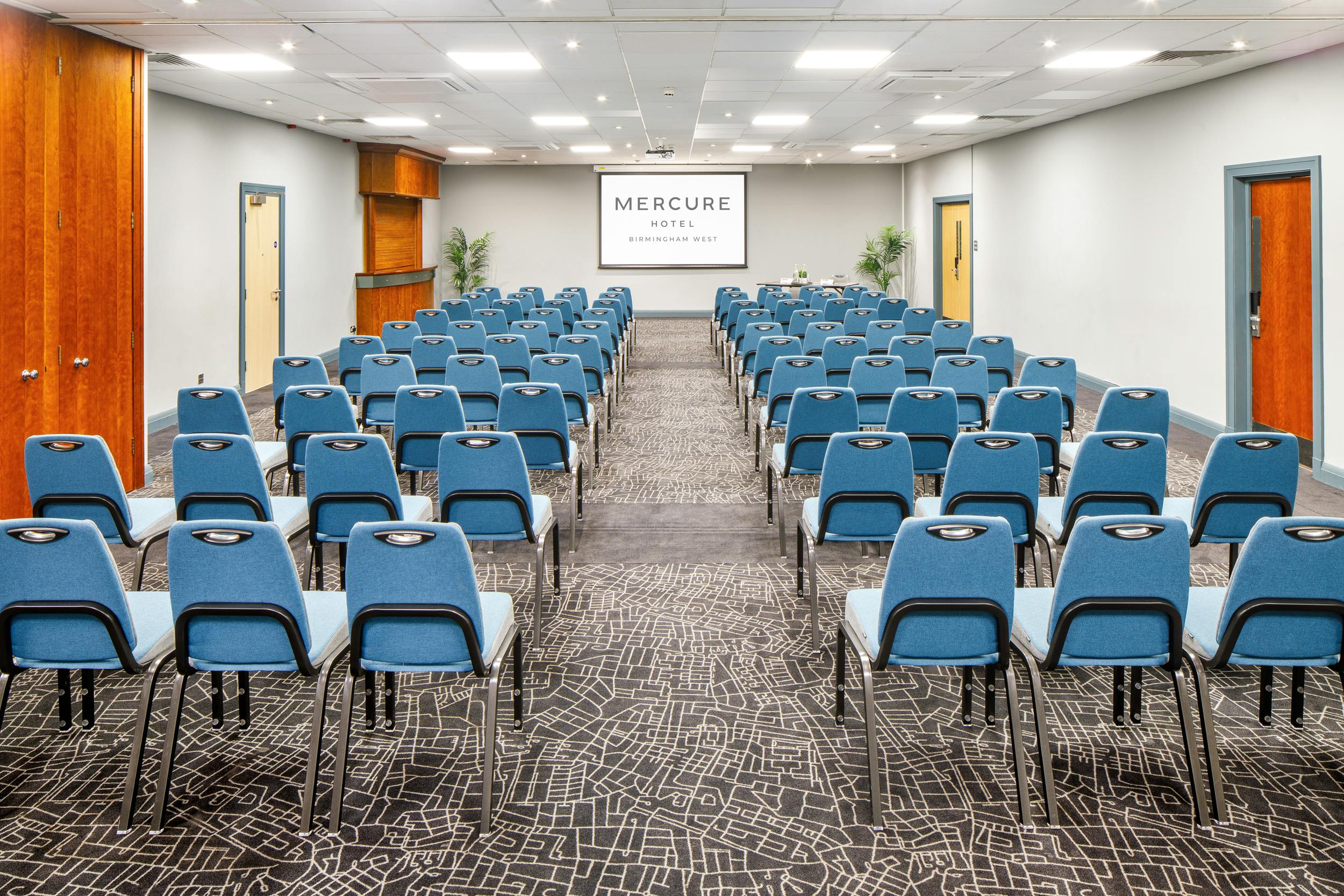 Hallard Suite at Mercure Birmingham: theater-style blue chairs for corporate conferences.