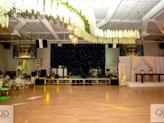 Spacious event hall with elegant stage, ideal for weddings and corporate events.