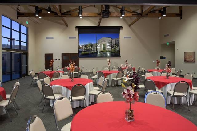 Ballroom event space with red tablecloths and floral centerpieces in Buena Park.