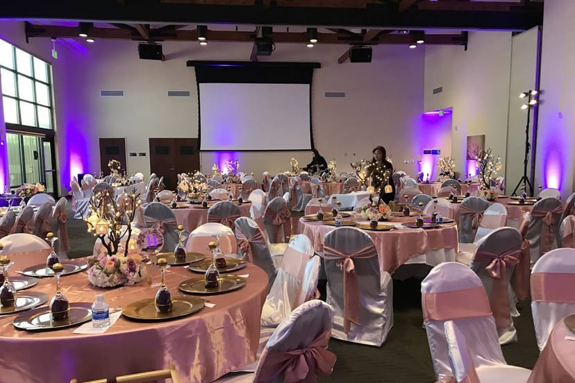 Elegant ballroom with pink linens, ideal for weddings and formal events.