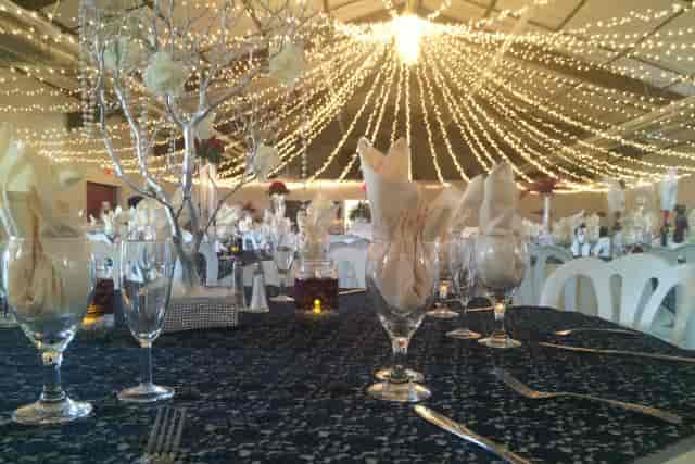 Elegant barn event space with fine table settings, ideal for weddings and gatherings.