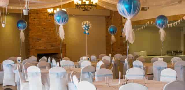 Bridal party in elegant event space with blue balloon centerpieces for weddings.