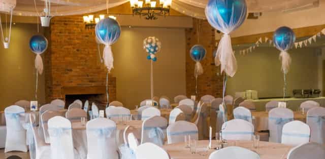 Bridal party in elegant event space with blue balloon centerpieces for weddings.