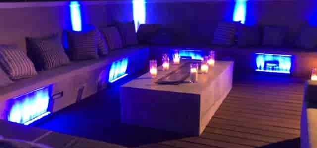 Bridal party in stylish outdoor lounge with blue lighting for networking events.