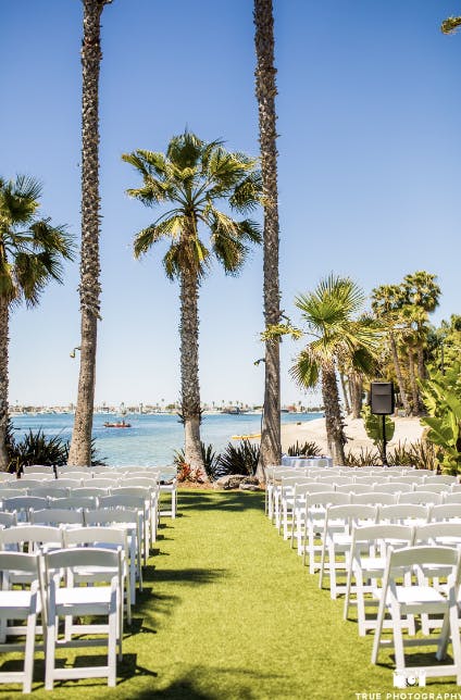 Outdoor wedding venue at Island Point Lawn with white chairs and waterfront view.