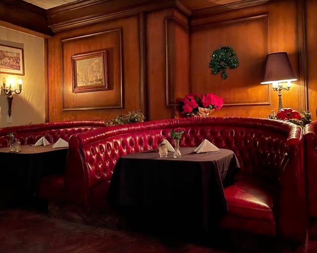 Cozy red leather booths in upscale dining space at IMPY Bar & Grill for private events.