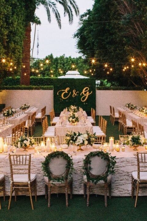 Elegant outdoor wedding reception with floral centerpieces and string lights.