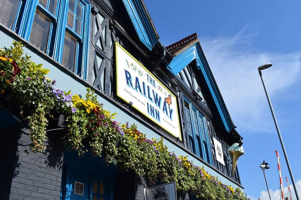 Charming Railway Inn venue with vibrant flowers, perfect for social events and meetings.