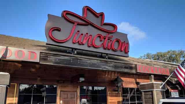 Rustic Scripps venue with neon "Junction" sign, perfect for casual events and gatherings.