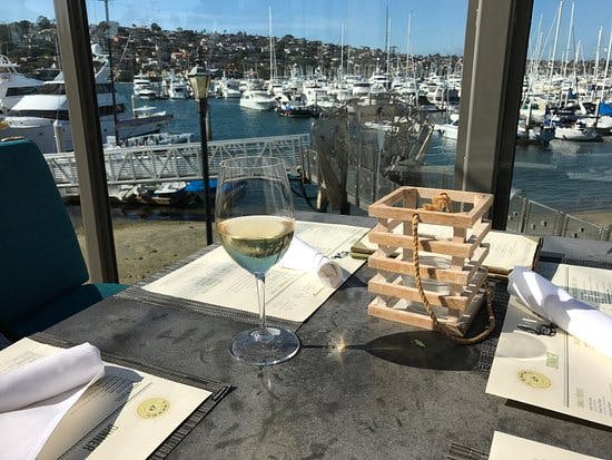 Elegant dining table with white wine at Vessel Restaurant + Bar, perfect for upscale events.