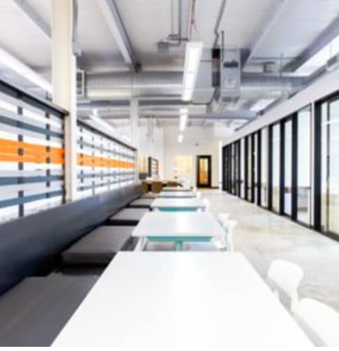 Modern shared desk in a bright, collaborative meeting space for workshops and networking.