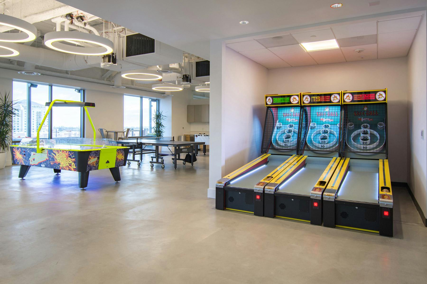 Modern glass-enclosed board room with air hockey for team-building events.