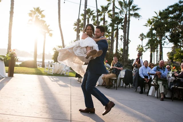 Couple celebrating at a wedding in a dance studio with sunset and palm trees.
