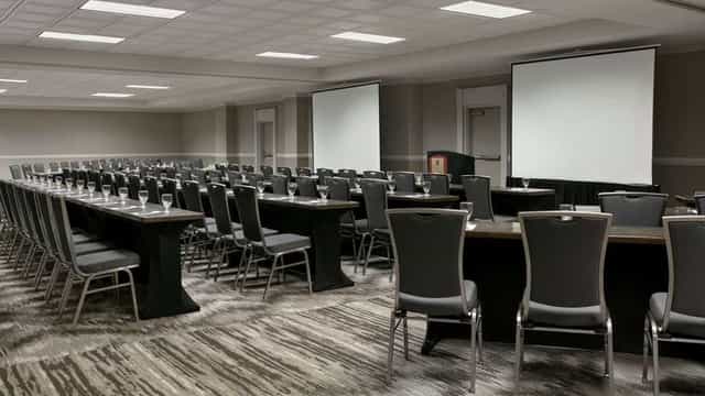 Conference room with dual screens for seminars and business meetings.