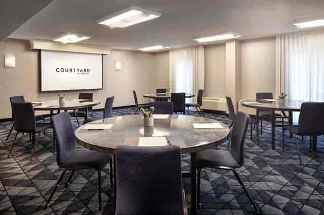 Meeting room with round tables and natural light for corporate meetings and workshops.