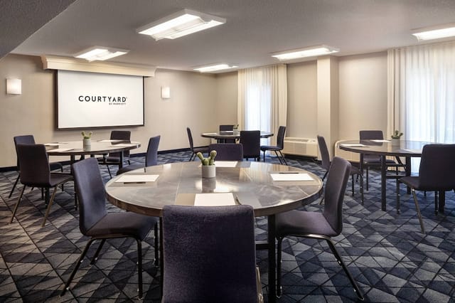 Meeting room with round tables and natural light for corporate meetings and workshops.