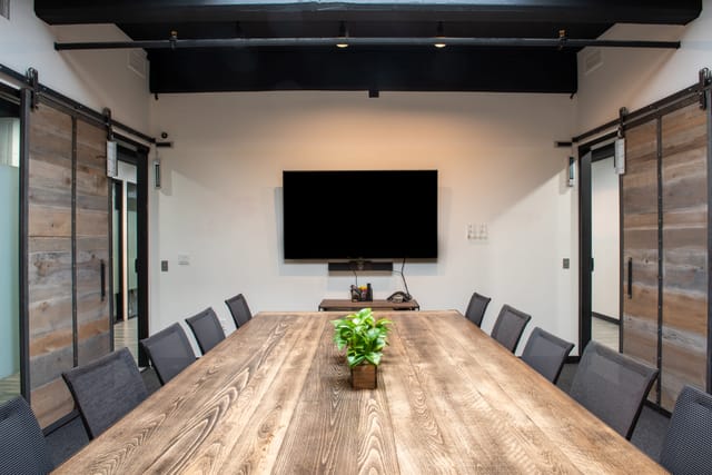 Modern meeting room with large wooden table, ideal for collaborative events and presentations.