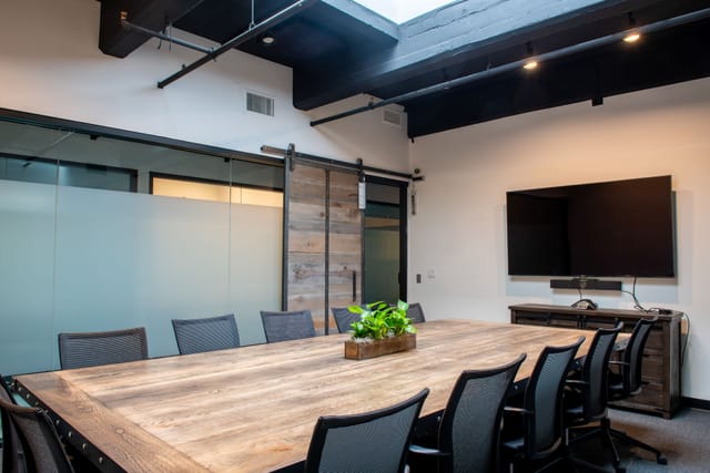 Modern meeting room with wooden table, ideal for collaboration and presentations.