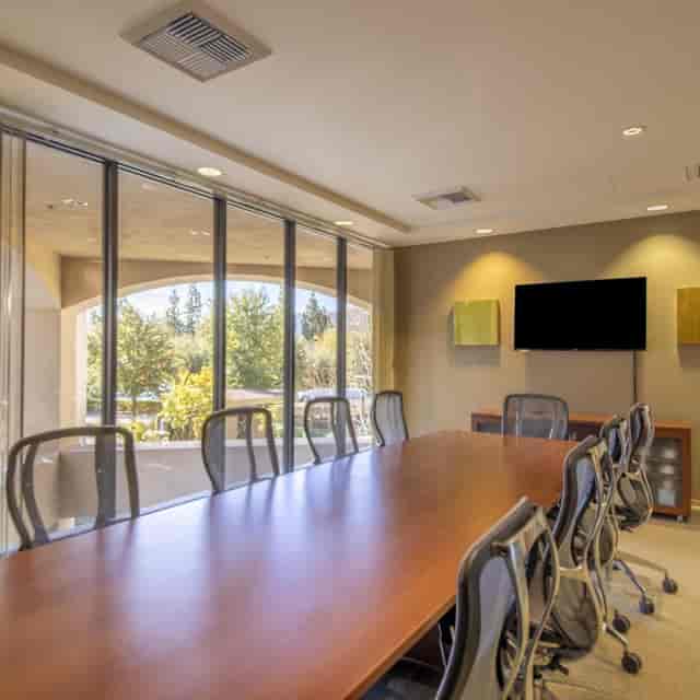 Modern conference room with wooden table, ideal for meetings and presentations.