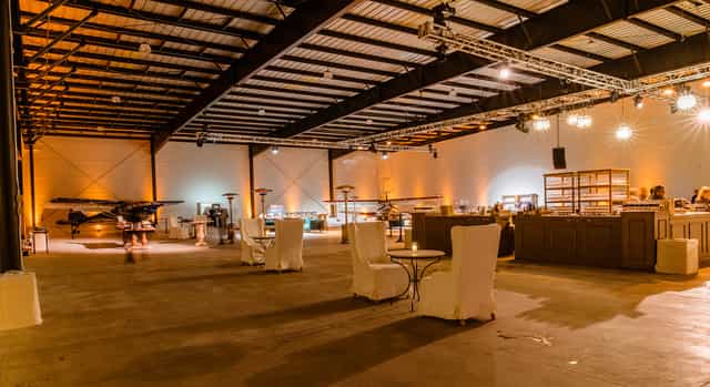 Spacious industrial event venue with aircraft, perfect for corporate gatherings and celebrations.