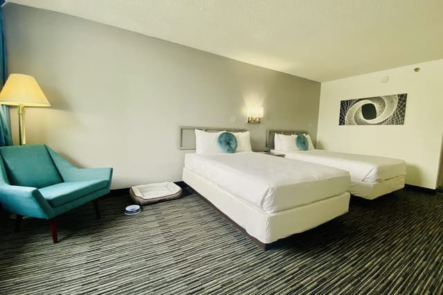 Well-lit Glendale hotel room with twin beds, perfect for events and networking.