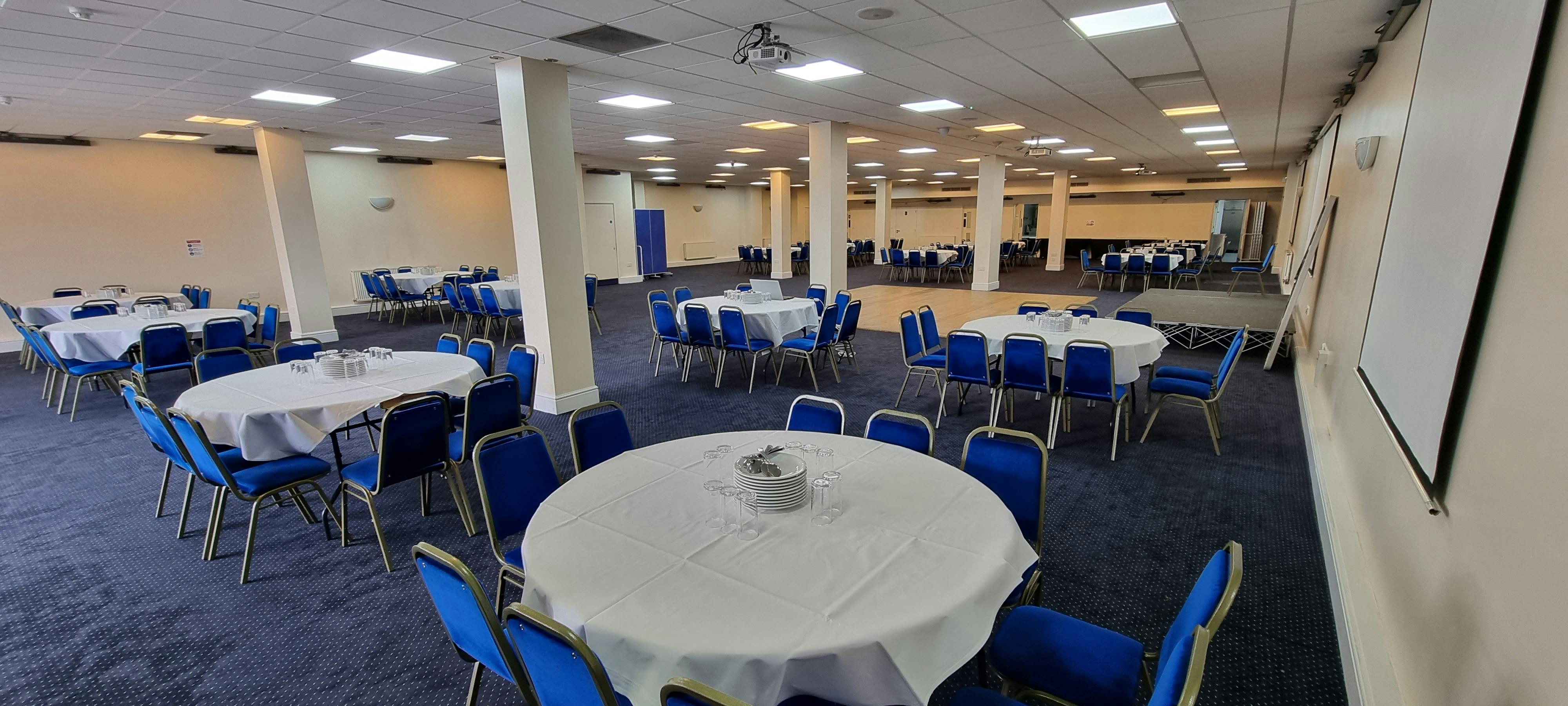 Saffron Suite conference venue with round tables, ideal for meetings and social events.