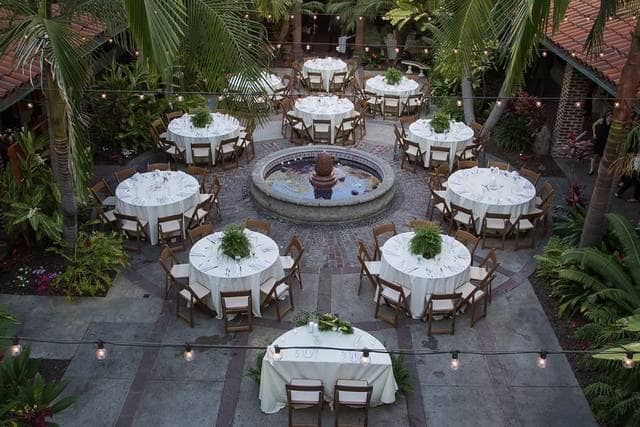 Elegant outdoor event space with round tables and a central fountain at Villa Del Sol.