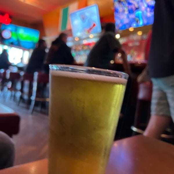 Beer glass in lively bar setting, ideal for networking events and casual gatherings.