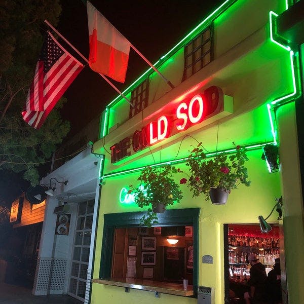 Vibrant restaurant exterior with neon signage, perfect for casual gatherings and events.