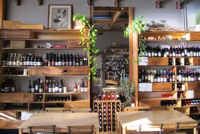 Stylish wine shop with wooden shelves, ideal for tastings and networking events.