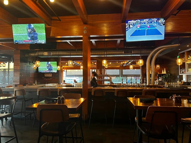 Modern bar at Jimmy's Famous American Tavern, perfect for casual meetings and sports events.